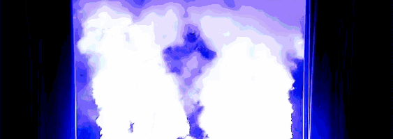 a person standing in front of a blue light with smoke coming out of them