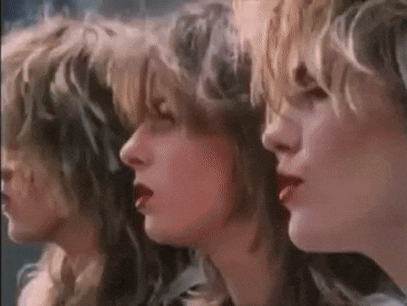 three women are standing next to each other in a row and looking at the camera .