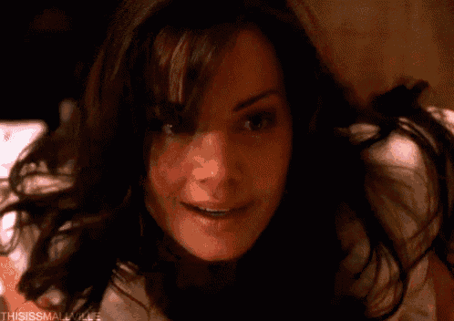 a close up of a woman 's face smiling while laying on a bed .