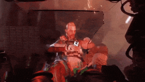 a man in a futuristic suit is sitting in a chair with a gun .