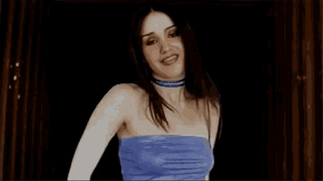 a woman in a blue strapless top is smiling