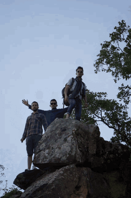 two people standing on top of a rocky cliff
