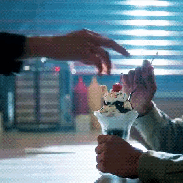a person is holding a sundae with a cherry on top of it