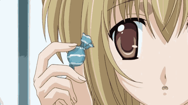 a girl with blonde hair is holding a blue and white candy