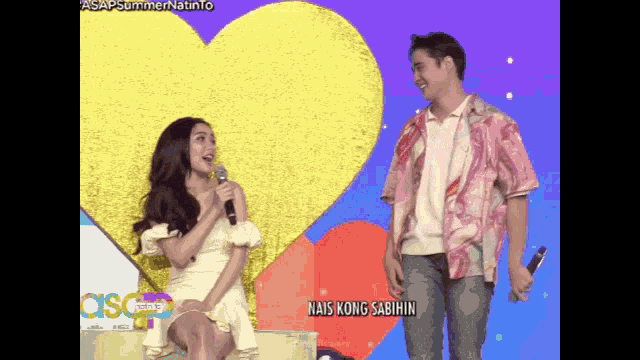 a man stands next to a woman holding a microphone with the words nais kong sabihin on the bottom