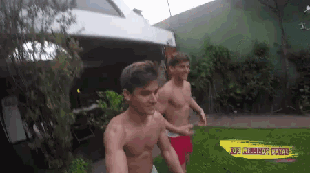 two shirtless men are standing next to each other in front of a sign that says los mellizos maya