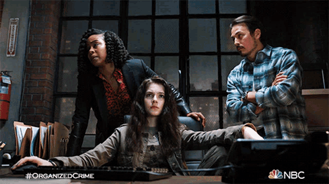 a poster for organized crime shows a woman using a computer and a man standing behind her