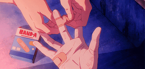 a person putting a bandage on another person 's hand next to a box of band-a