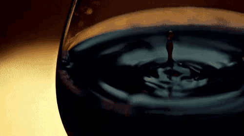 a drop of liquid is being poured into a glass of water