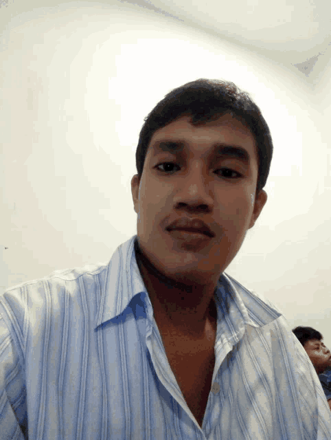 a man in a striped shirt takes a selfie