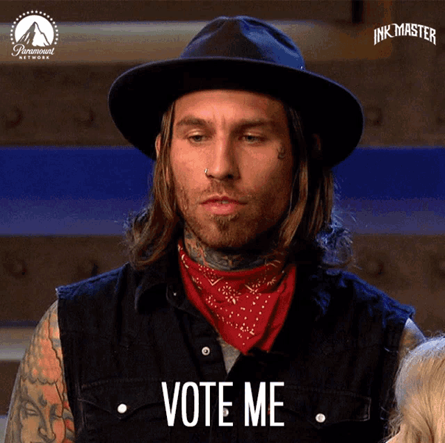 a man wearing a black hat and a red bandana says " vote me "