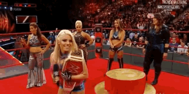 a woman in a wrestling ring holding a wrestling championship belt