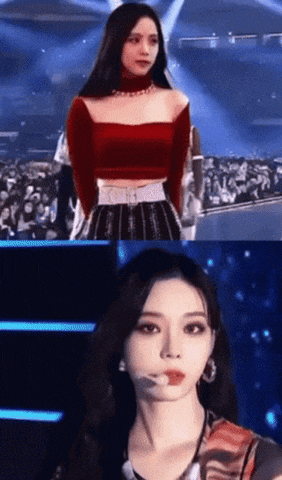 a woman in a red top and black skirt is standing on a stage