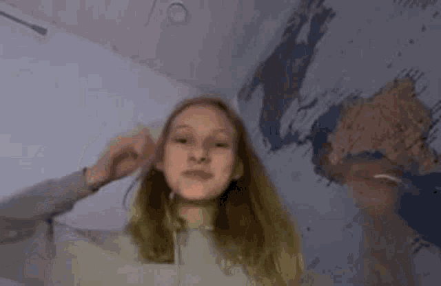 a young girl wearing headphones is standing in front of a wall with a map on it .