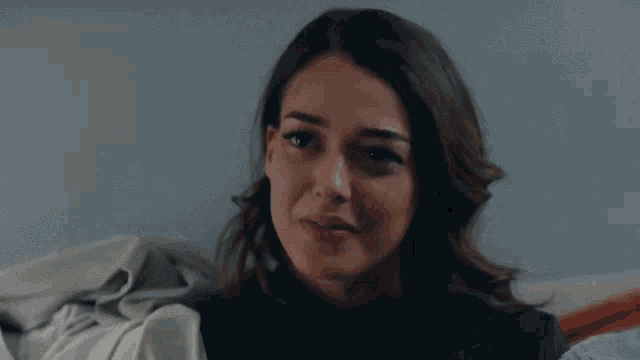 a woman is smiling and holding a blanket in her hands