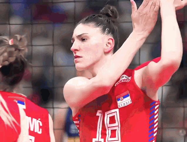 a female volleyball player wearing a jersey with the number 18 on it