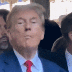 a man in a blue suit and red tie stands in a crowd