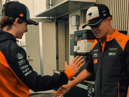 two men shaking hands with one wearing a jacket that says dell on it