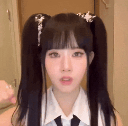 a girl with pigtails and a tie is wearing a white shirt and tie .