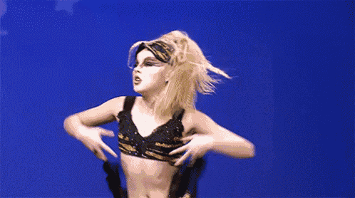 a woman in a tiger print top is jumping in the air with her arms in the air .