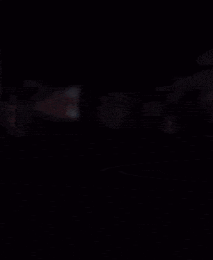 a man wearing a green mask and a hoodie is dancing in a bus .