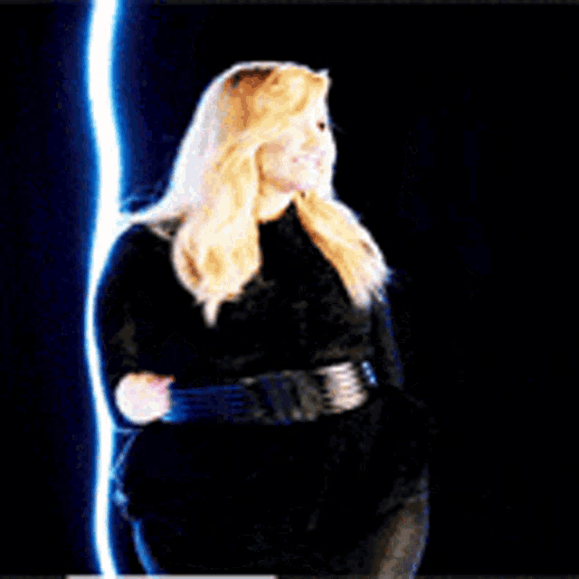 a woman with blonde hair is holding a light saber in her hand