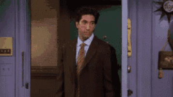 a man in a suit and tie is standing in the doorway of a building .