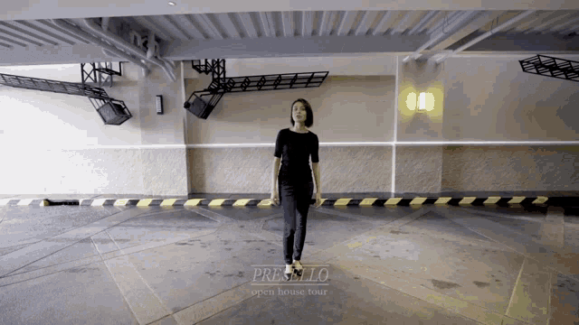 a woman is walking in a parking garage that says presello