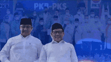 two men are standing in front of a pkb-pks logo