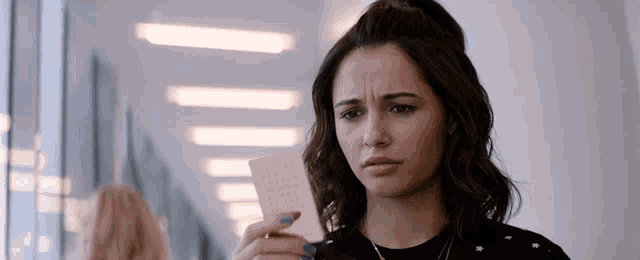 a woman with blue nail polish is holding a piece of paper that says ' i love you ' on it