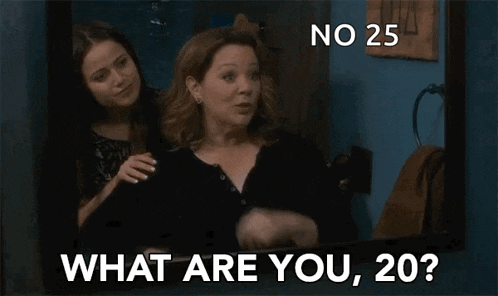 two women are standing next to each other in front of a mirror and one of them is asking the other what are you , 20 ?