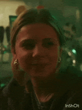 a close up of a woman 's face smiling in a dark room .