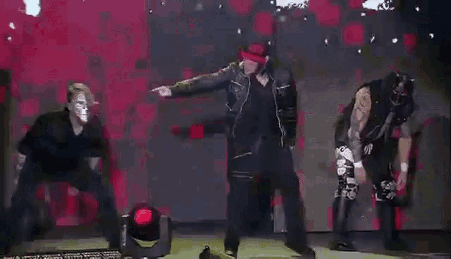 a group of men are dancing on a stage in front of a large sign that says a .