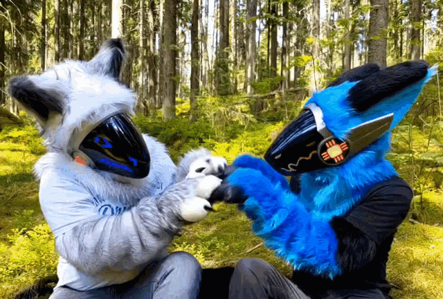 two people in furry costumes are playing with a stuffed animal
