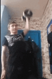 a man is lifting a dumbbell in a room with a blue door .