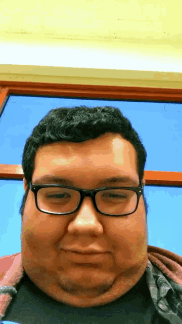 a man with glasses and a black shirt is smiling