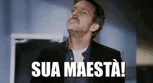 a man in a suit is standing in front of a sign that says sua maestà .