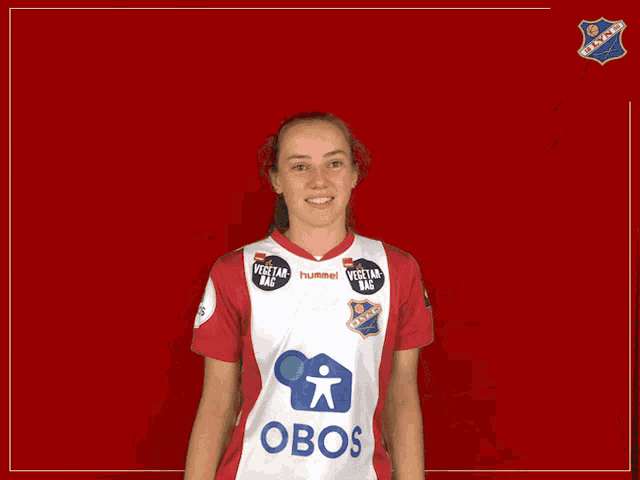 a woman wearing a red and white jersey with the word obos on it