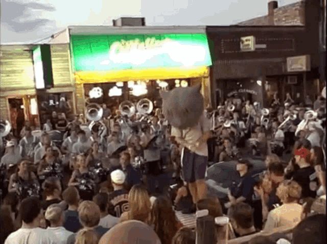 a crowd of people are gathered in front of a building that says buffalo wings