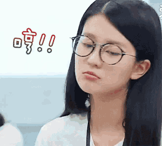a woman wearing glasses and a white shirt is making a sad face .