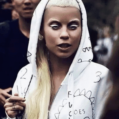 a woman wearing a white hoodie with the word goes on it .