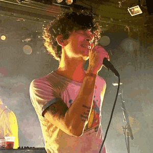 a man is singing into a microphone on stage .