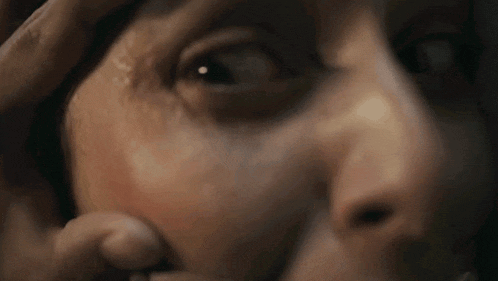 a close up of a person 's face with their hand on their forehead .