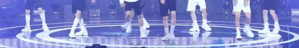 a group of people are dancing in a circle on a stage