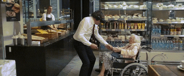 an elderly woman in a wheelchair is being helped by a man in a bakery