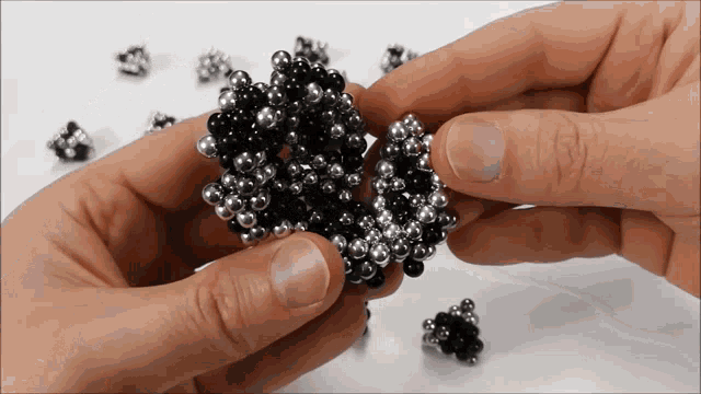 a person is holding a bunch of metal beads in their hands