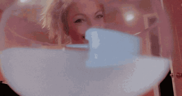 a woman is taking a picture of herself in a mirror and smiling .
