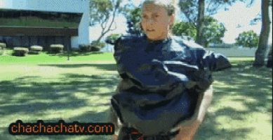 a woman is standing in a park with the website chachachatv.com visible