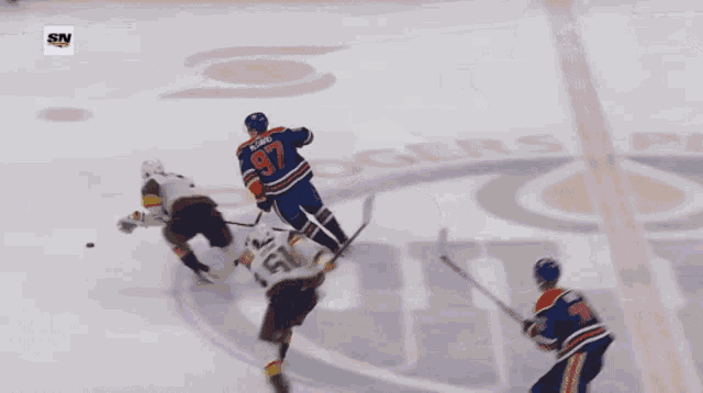 a hockey player with the number 20 on his jersey is being chased by another player