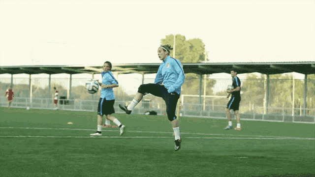 a group of soccer players are playing on a field and one of them is wearing a blue jersey that says nike